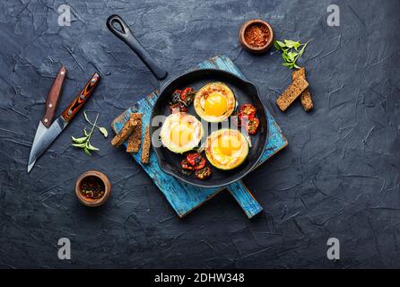 Spiegeleier mit Tomaten und Brot in der Pfanne Stockfoto