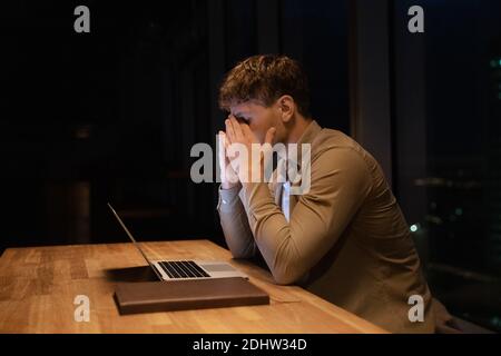 Müde männliche Mitarbeiter Überarbeit im Büro in der Nacht Stockfoto