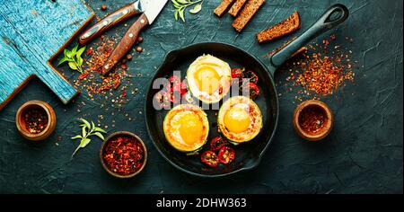 Spiegeleier mit Tomaten und Brot in der Pfanne Stockfoto