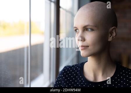 Nahaufnahme nachdenkliche haarlose Frau Krebspatientin Blick in Fenster Stockfoto