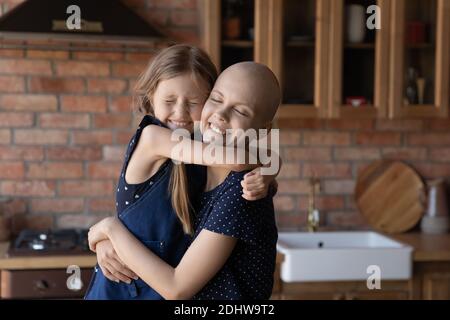 Nahaufnahme glücklich krank haarlos Mutter und kleine Tochter kuscheln Stockfoto
