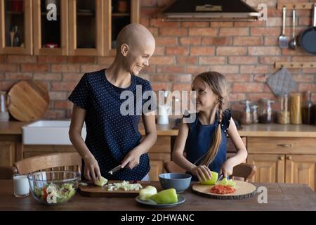 Glückliche kranke Mutter Krebs-Patientin und kleine Tochter Kochen zusammen Stockfoto