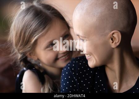 Nahaufnahme glücklich Krebs krank Mutter und kleine Tochter umarmen Stockfoto