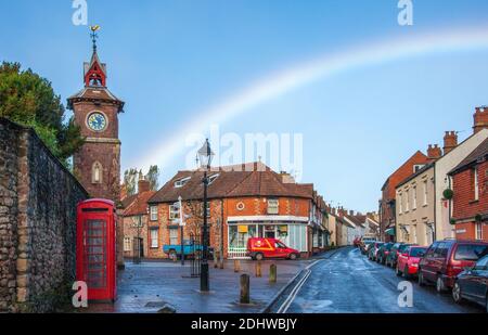 Regenbogen über dem Dorfplatz und Uhrenturm von Nether Stowey in den Quantock Hills von Somerset UK Stockfoto