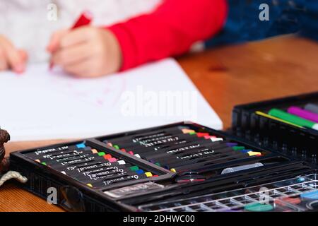 Reiche Reihe von Zeichenwerkzeugen mit linkshändigen Kinderzeichnungen Im Hintergrund Stockfoto