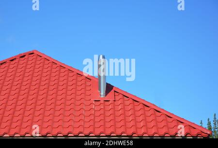 Neues rotes Ziegeldach mit Metallkamin Haus Dachkonstruktion außen. Stockfoto