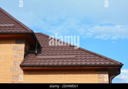 Dach mit New House Regenrinne Abdichtung. Dachrinnen-Fittings Regenrinnensystem und Dachschutz mit Snowboards, Schneeschutz. Stockfoto