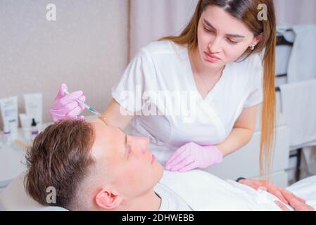 Männliche Kosmetik. Ein gut aussehender Mann, der im luxuriösen Spa eine Gesichtsbehandlung bekommt Stockfoto