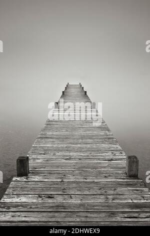 Ein Steg verschwindet im Nebel am Lake Windermere Stockfoto