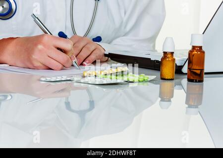 Eine junge Ärztin schreibt Medicamente. Receptted Tabletts are from Arzt verordnet. Stockfoto
