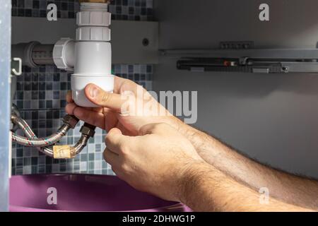 Der Klempner entfernt die Verstopfung in den Rohren Stockfoto
