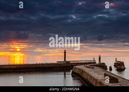 Sunburst durch die Wolken über Whitby Pier Stockfoto