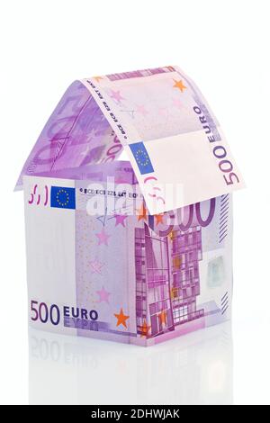 Ein Haus gebaut aus 500er Euro Bankknoten auf weißem Hintergrund. Bausparen, Hausbau und Hauskauf. Stockfoto