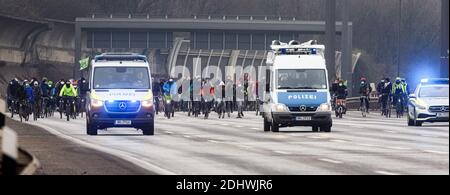 Hamburg, Deutschland. Dezember 2020. Begleitet von Polizeifahrzeugen fahren die Teilnehmer der Fahrraddemonstration entlang der Autobahn A255. Die Initiative 'End Gelände' hatte die Demonstration unter dem Motto 'Fahrrad fahren statt Autobahn - Fahrraddemonstration in Solidarität mit dem Dannenröder Forst zum 5. Jahrestag des Pariser Klimaschutzabkommens' gefordert. Quelle: Markus Scholz/dpa/Alamy Live News Stockfoto