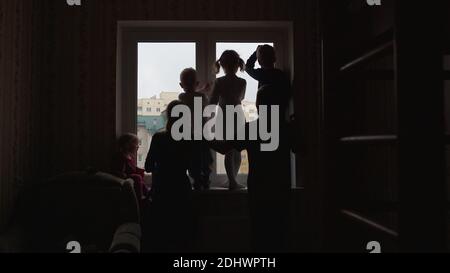 Silhouette einer großen Familie auf dem Hintergrund eines Fensters in einer neuen Wohnung. Stockfoto