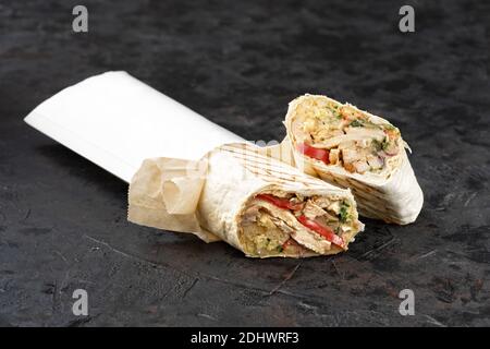 Traditionelles orientalisches Shawarma aus umweltfreundlicher Pappe. Oberfläche aus dunklem Stein. Konzept von Öko-Verpackungen von Wertstoffen. Speicherplatz kopieren Stockfoto