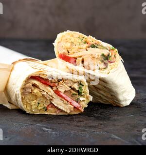 Traditionelles orientalisches Shawarma aus umweltfreundlicher Pappe. Oberfläche aus dunklem Stein. Konzept von Öko-Verpackungen von Wertstoffen. Kopierbereich 1:1 Stockfoto