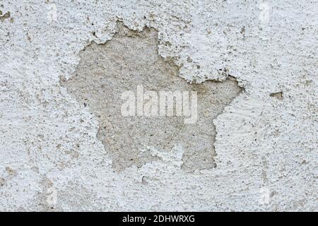 Abblätternde Farbe in der Mitte einer abblätternden weißen Wand. Retro und Vintage abstrakter Hintergrund. Stockfoto