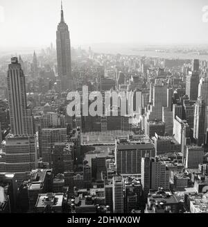 1960er Jahre, historische Luftaufnahme über Manhattan, New York City, zeigt die Tower Blocks und Wolkenkratzer. Stockfoto