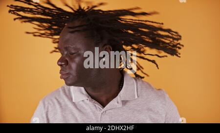 Junger afroamerikanischer Schwarzer schüttelt den Kopf mit Dreadlocks. Hochwertige Fotos Stockfoto