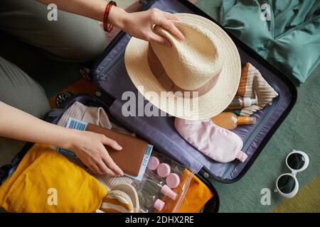 Nahaufnahme einer Frau, die ihre Kleidung im Koffer packt, ist sie Wir fahren in den Urlaub Stockfoto