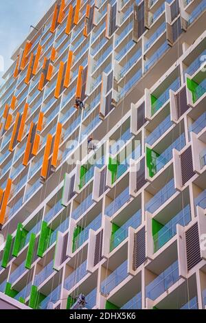 Zwei Maler hängen, die in einem neu erbauten Eigentumswohnungsgebäude arbeiten. Stockfoto