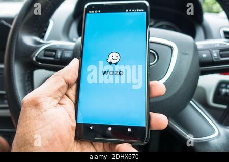 Waze Richtungsanwendung auf Handy im Auto mit Lenkung Rad Stockfoto