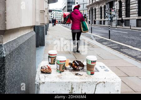 Kaffeetassen, Alkoholflasche und Abfall auf dem Bürgersteig Stockfoto