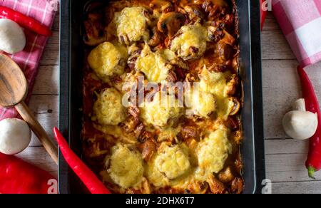 Im Ofen gebackene Schweinefilet-Medaillons mit Pilzcreme-Sauce Garniert mit geschmolzenem gouda-Käse Stockfoto
