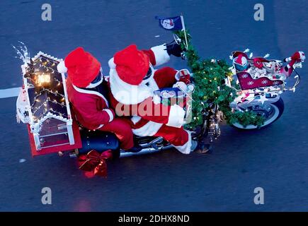 Berlin, Deutschland. Dezember 2020. Zwei Motorradfahrer fahren mit einer Weihnachtskutsche, einem Lebkuchenhaus und als Weihnachtsmann gekleidet die Torstraße entlang. Über hundert Weihnachtsmänner nehmen an der 23. Berlin Christmas Bike Tour 2020 Teil. Quelle: Annette Riedl/dpa/Alamy Live News Stockfoto