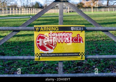 Ein Schild an einem Metalltor am Eingang zu einem Feld warnt die Menschen, dass in diesem Bereich eine Landuhr in Kraft ist. Stockfoto