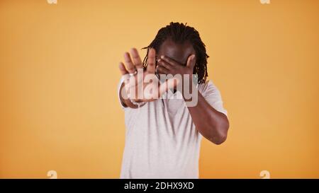 Stopp. Junger afroamerikanischer schwarzer Mann, der die Hand über die Augen hält und mit der anderen Hand Halt zeigt. Hochwertige Fotos Stockfoto
