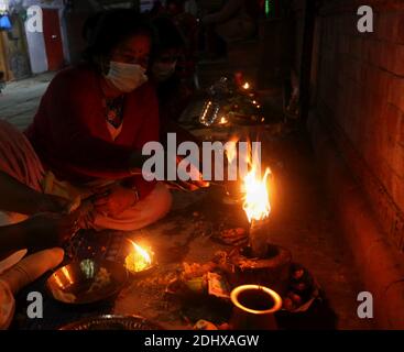 Kathmandu, Bagmati, Nepal. Dezember 2020. Ein nepalesischer Hindu-Anhänger zündet während des Bala Chaturdashi-Festivals, in Erinnerung an deceasedÂ Geliebte, in Kathmandu, Nepal am 12. Dezember 2020, Öllampe an.Â das Bala Chaturdashi-Festival wird zu Ehren der verstorbenen Familienmitglieder gefeiert, bei denen Anhänger sieben verschiedene Arten von Samen streuen. Eifrige Anhänger verbrachten eine ganze Nacht wach und zündeten Öllampen im Namen des Gedächtnisses des Verstorbenen, vor einem Tag an. Viele Menschen sind in diesem Jahr an COVID-19 gestorben. Quelle: Sunil Sharma/ZUMA Wire/Alamy Live News Stockfoto