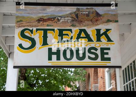 Virginia City, Montana - 29. Juni 2020: Altes historisches Zeichen für das Wells Fargo Steak House Restaurant, in der Geisterstadt Stockfoto