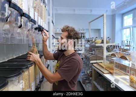 Deutschland / Berlin / Kunden bringen ihre eigenen Behälter mit und füllen sie mit allem von Pasta il bis Spülmittel, bei Original Unverpackt. Stockfoto