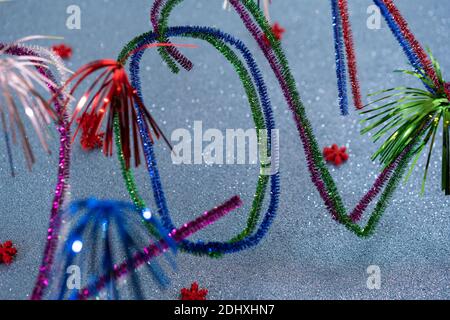 2021 Neujahrspostkarte mit funkelnden bunten Zahlen. Präsentiert von Pfeifenreinigern oder Whistle Washer, glitzernden türkisfarbenen Hintergrund mit roten festlichen Stockfoto