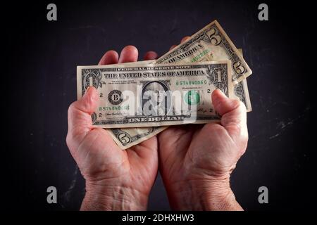 Dollar in den Händen einer älteren Frau, Nahaufnahme, Vignettierung. Stockfoto