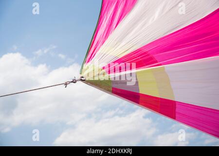 Bunte Segel gegen einen blauen Himmel mit weißen Wolken, hellen Farben, Segeln Stockfoto