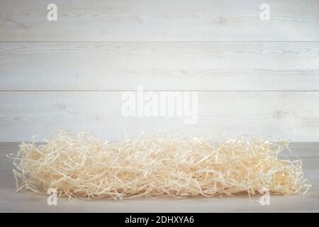 Stroh Verpackungsmaterial auf weißem Holz Wand Hintergrund. Stockfoto