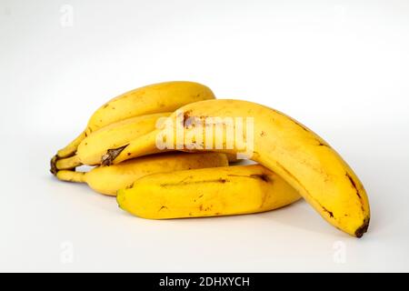 Bananen mit einigen dunklen Flecken mit Schatten isoliert auf weißem Hintergrund. Stockfoto
