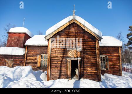 Alte samische Kirche bedeckt mit Schnee in Pielpajarvi, in der Nähe des gefrorenen Sees von Inari.Lappland, Finnland Stockfoto