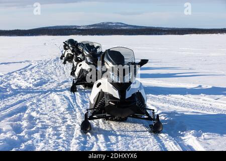 Schneemobil-Touristik-Tour auf dem zugefrorenen See von Inari, in Lappland, Finnland Stockfoto