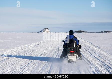 Schneemobil-Touristik-Tour auf dem zugefrorenen See von Inari, in Lappland, Finnland Stockfoto
