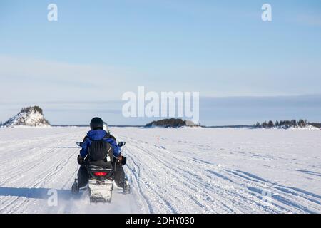 Schneemobil-Touristik-Tour auf dem zugefrorenen See von Inari, in Lappland, Finnland Stockfoto