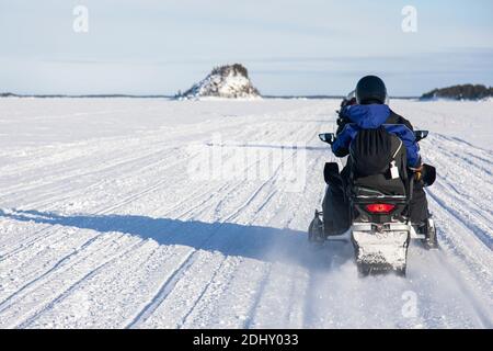 Schneemobil-Touristik-Tour auf dem zugefrorenen See von Inari, in Lappland, Finnland Stockfoto