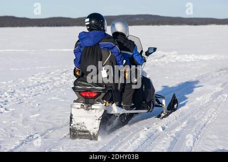 Schneemobil-Touristik-Tour auf dem zugefrorenen See von Inari, in Lappland, Finnland Stockfoto