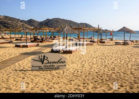 IOS, Griechenland - 20. September 2020: Strandbar-Restaurant mit Liegestühlen und Sonnenschirmen am Mylopotas-Strand auf der Insel iOS. Griechenland Stockfoto