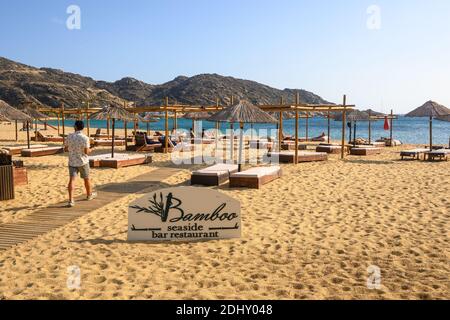 IOS, Griechenland - 20. September 2020: Strandbar-Restaurant mit Liegestühlen und Sonnenschirmen am Mylopotas-Strand auf der Insel iOS. Griechenland Stockfoto