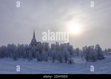 Lappland, Finnland: Panoramablick auf eine Kirche in einem verschneiten Wald nahe der Grenze zwischen Finnland und Schweden Stockfoto