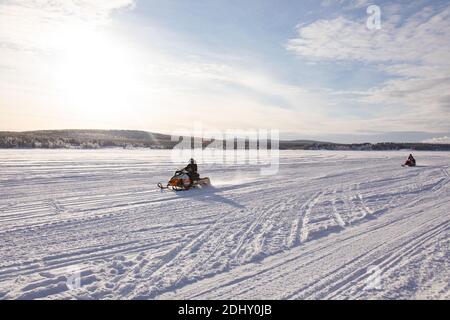 Touristische Schneemobiltour auf einem gefrorenen Fluss in Jukkasjarvi, Kiruna Provinz, Lappland Schweden Stockfoto